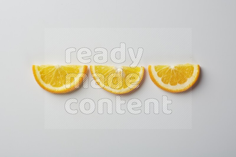 Three halves of an orange slices on white background