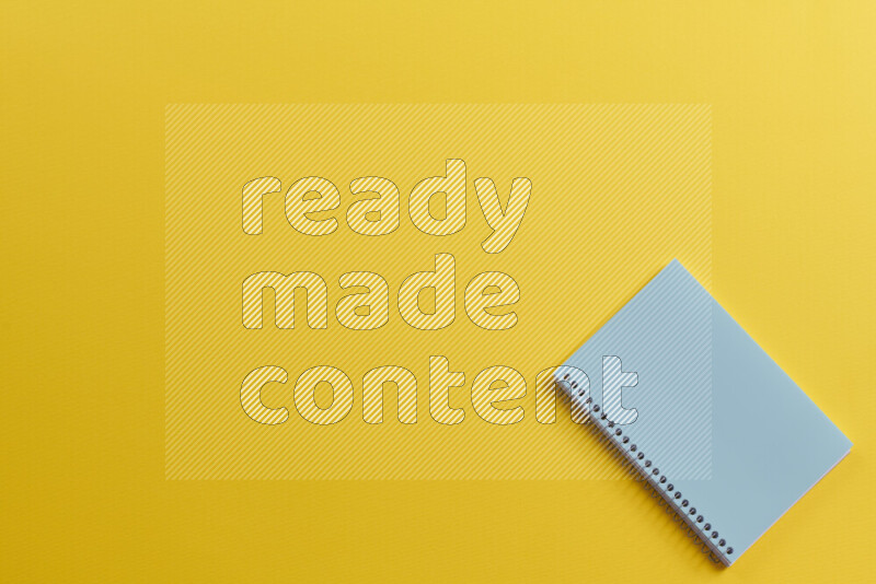 دفتر ملاحظات أزرق مع مستلزمات مدرسية مختلفة على خلفية صفراء