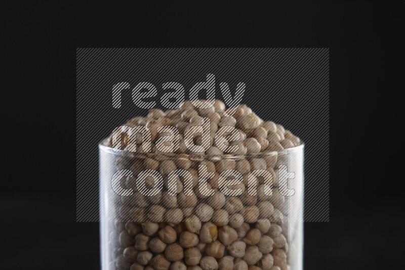 Chickpeas in a glass jar on black background