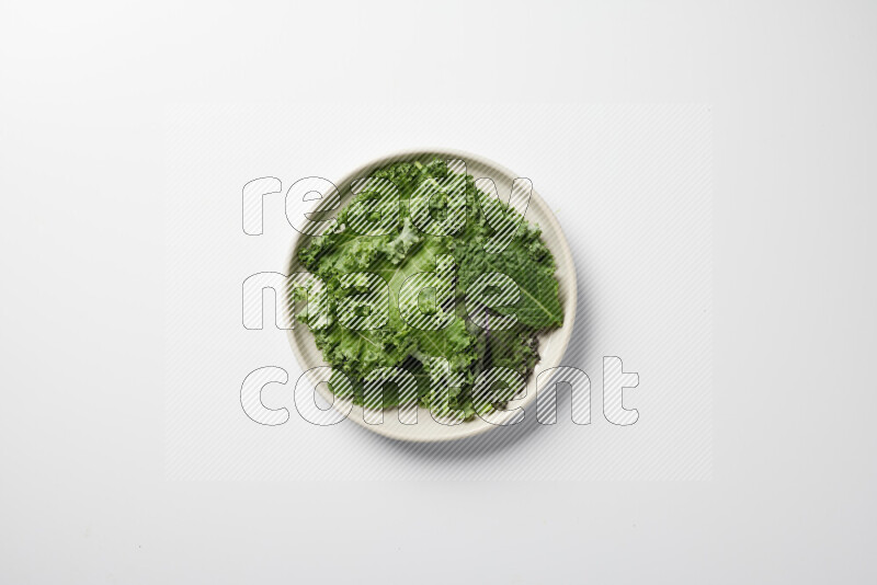 A bowl of fresh vegetables salad with kale leaves, cherry tomatoes, sliced radishes and sliced cucumber on a white background