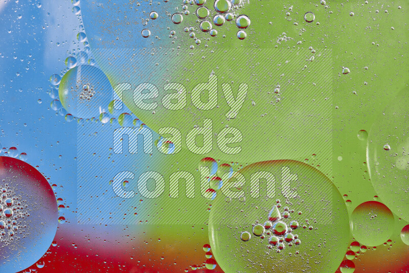 Close-ups of abstract oil bubbles on water surface in shades of red, green and blue