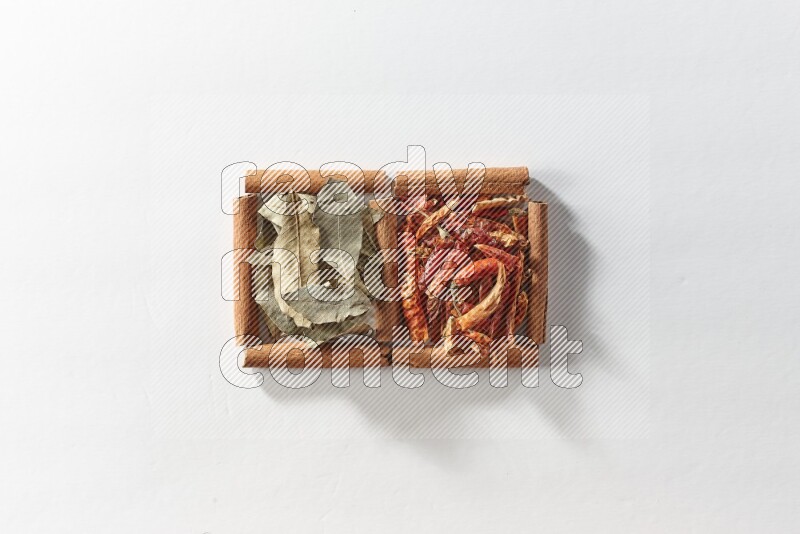 2 squares of cinnamon sticks full of dried red chilis and bay laurel leaves on white flooring