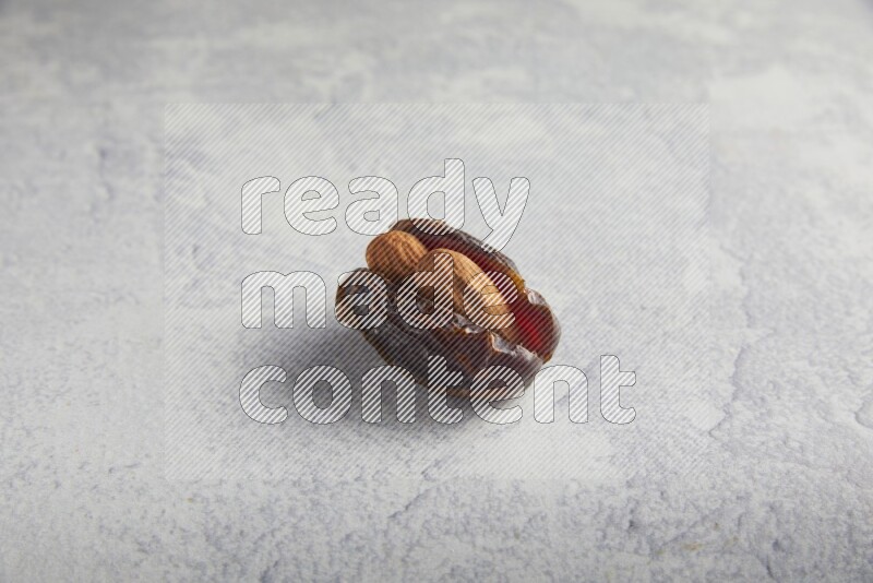 almond stuffed madjoul date on a light grey background