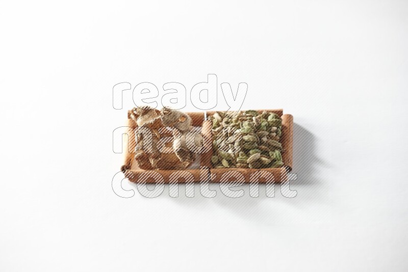 2 squares of cinnamon sticks full of cardamom and dried ginger on white flooring