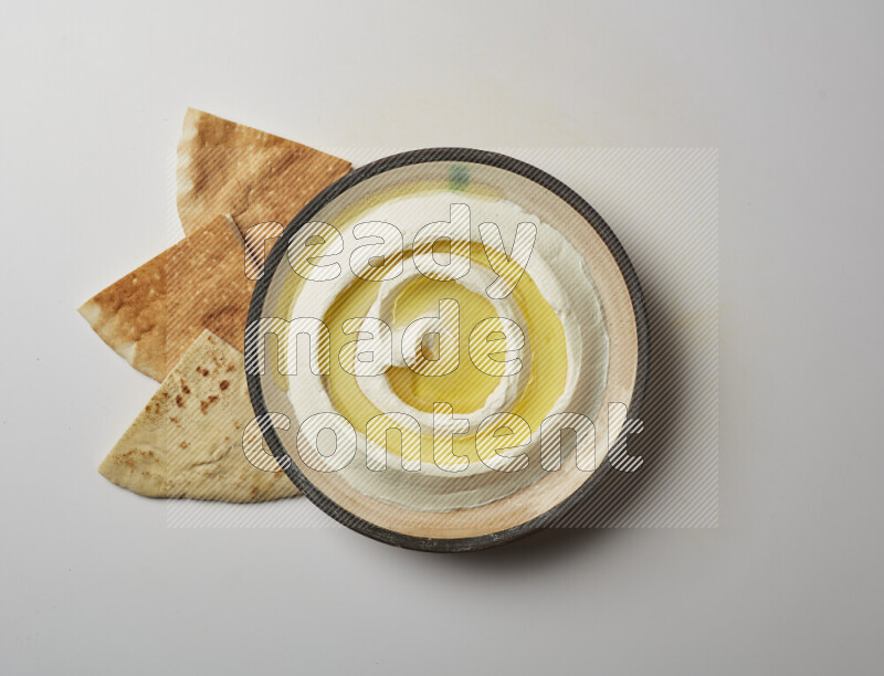 Lebnah garnished with olive oil in a pottery plate on a white background