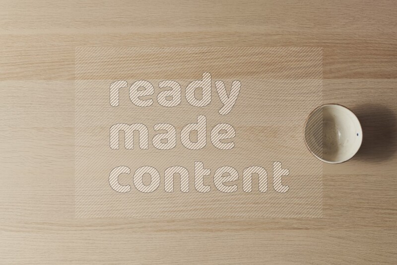 وعاء فخاري أبيض على خلفية خشبية فاتحة