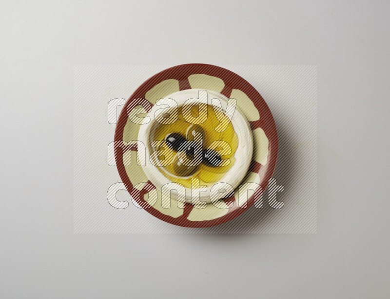 Lebnah garnished with olives in a traditional plate on a white background