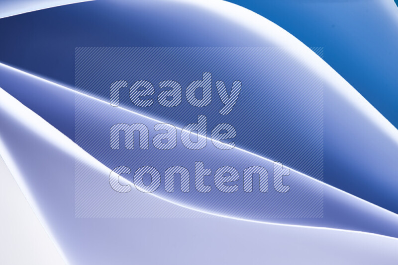This image showcases an abstract paper art composition with paper curves in blue and white gradients created by colored light