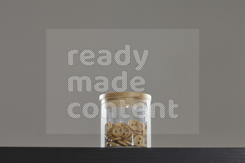 أزرار متنوعة في وعاء زجاجي علي خلفية سوداء