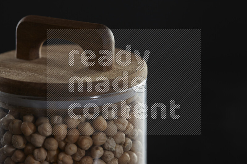 Chickpeas in a glass jar on black background