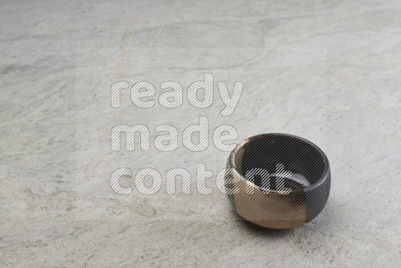 A multicolored pottery bowl on grey marble background