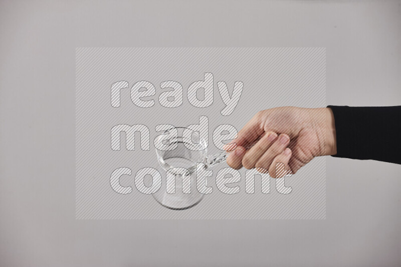 A woman in black abaya holding different glassware in different positions