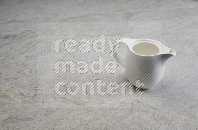 A ceramic milk jug on grey marble background