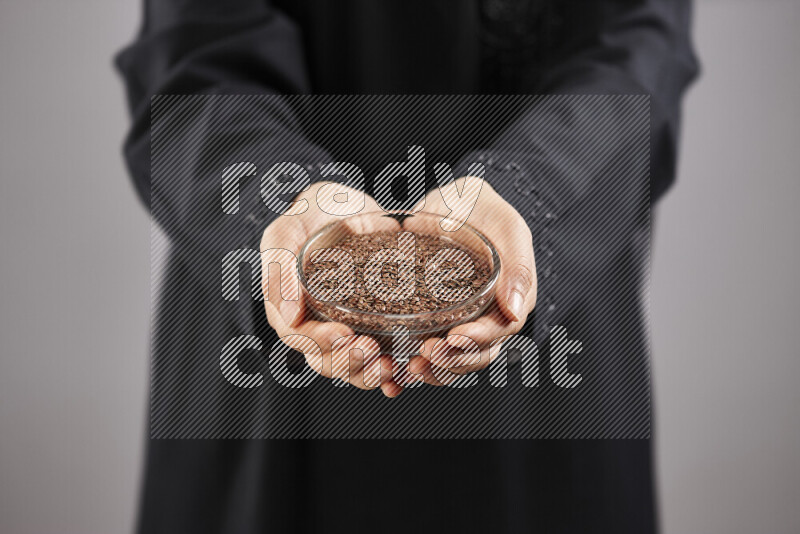 Woman in abaya holding different kinds of spices in different positions