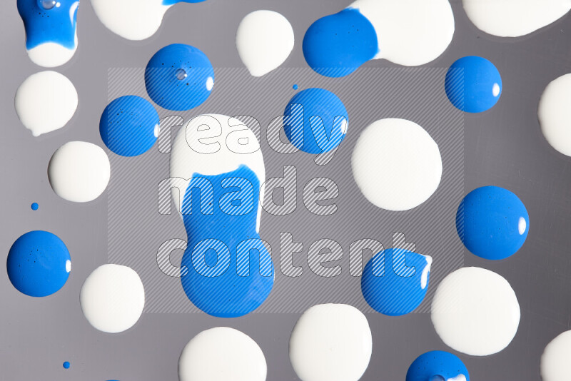 Close-ups of abstract white and blue paint droplets on the surface