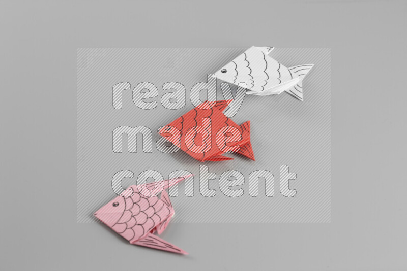 Origami fish on grey background