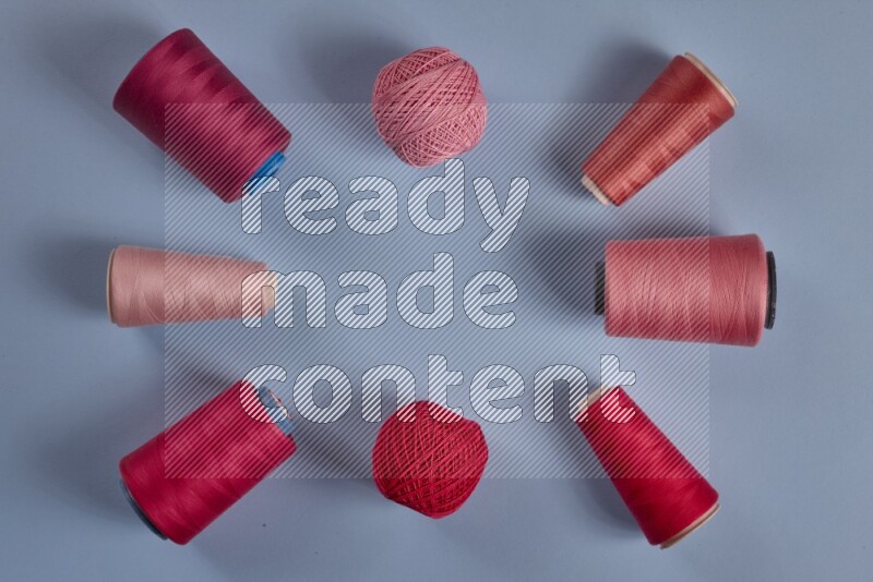 مجموعة من أدوات الخياطة والتفصيل زهرية اللون على خلفية زرقاء