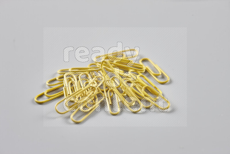 Yellow paper clips isolated on a grey background