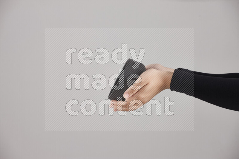 A woman in black abaya holding different pottery essentials in different positions