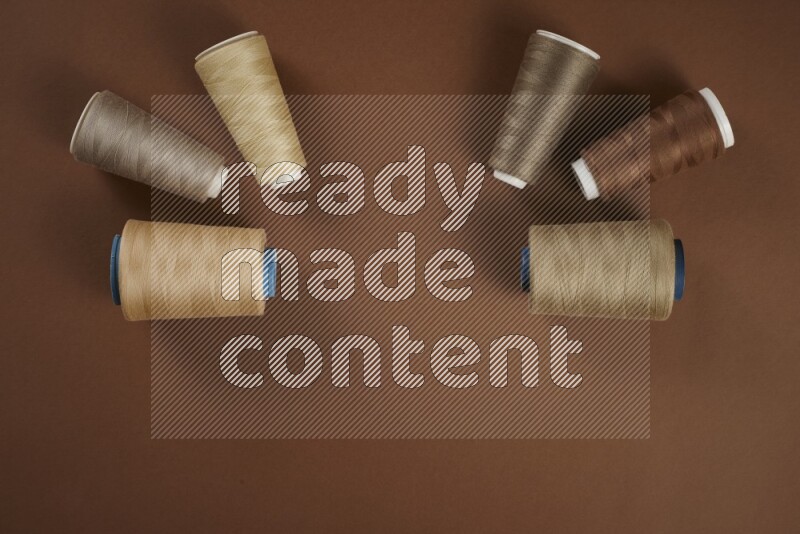 A brown collection of sewing and tailoring tools arranged on a brown background