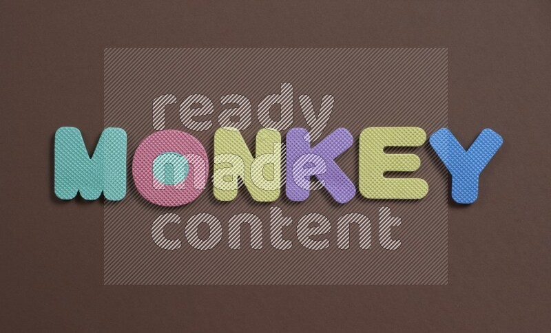 The word (Monkey) in foam letters for kids on brown background (kids toys)