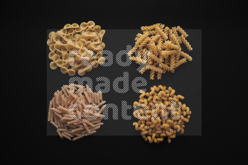 Different pasta types in bunches on black background