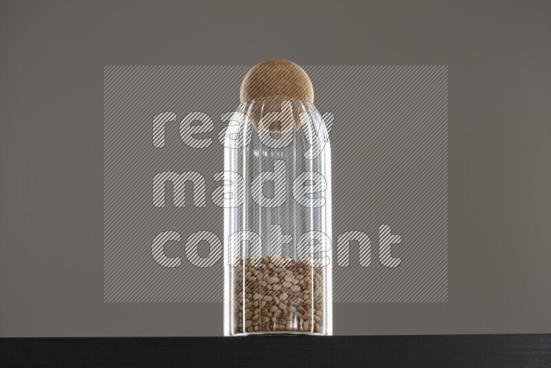 Black-eyed peas in a glass jar on black background