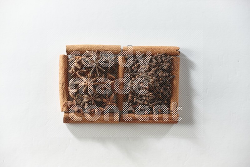 2 squares of cinnamon sticks full of cloves and star anise on white flooring