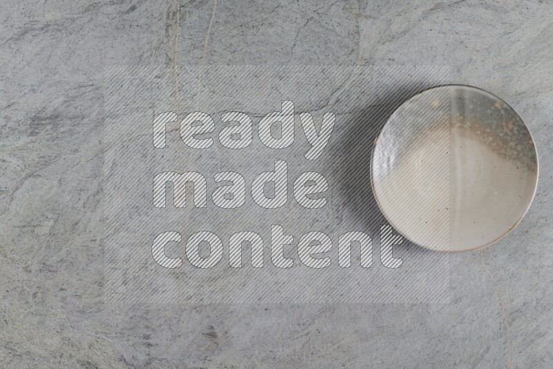 A multicolored pottery plate on grey marble background