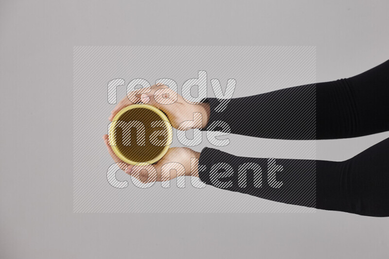 A woman in black abaya holding different pottery essentials in different positions