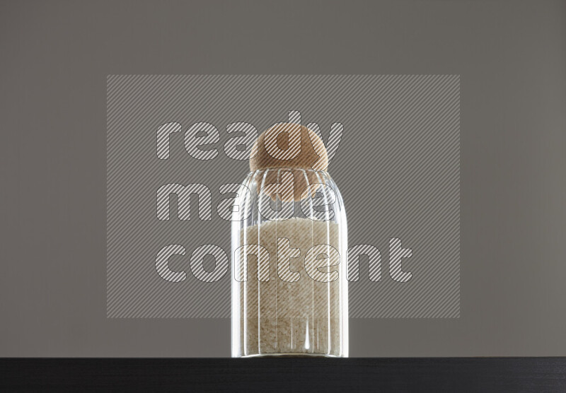 White rice in a glass jar on black background