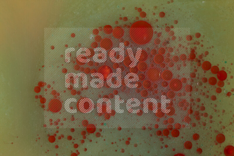 The image captures a dramatic splatter of red, green and yellow paints over the backdrop