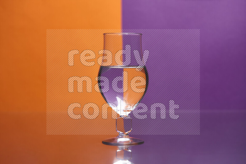 The image features a clear glassware filled with water, set against orange and purple background