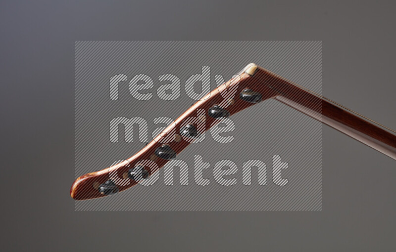 parts of a brown wooden Oud in a gray background