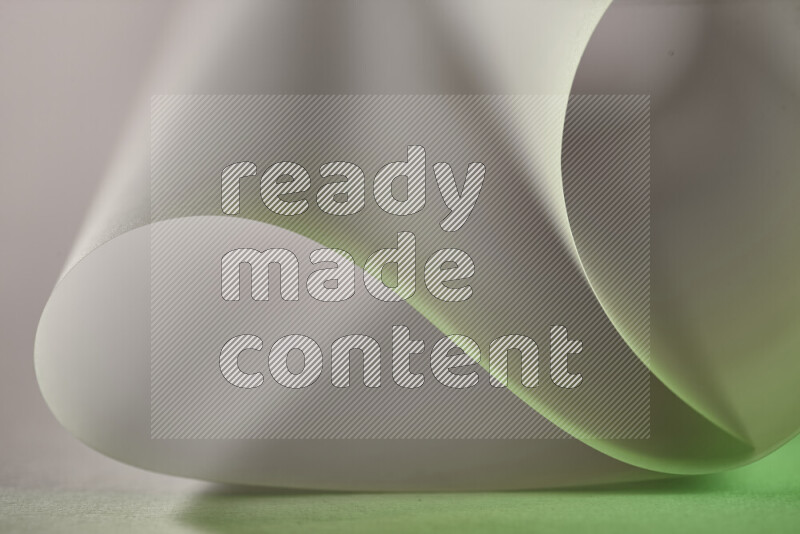 An abstract art piece displaying smooth curves in green and grey gradients created by colored light