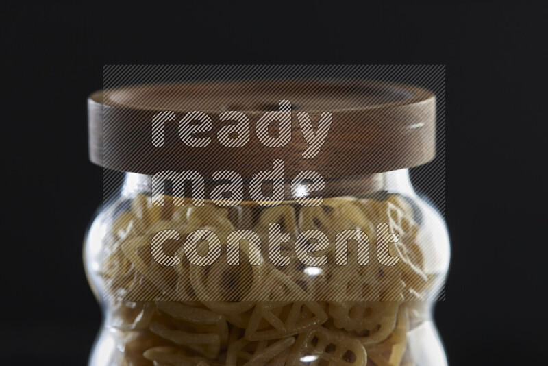 Snacks in a glass jar on black background