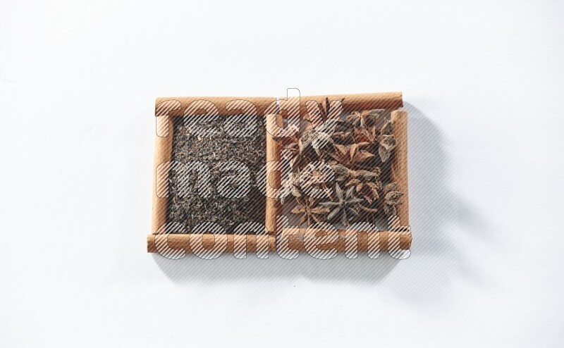 2 squares of cinnamon sticks full of black tea and star anise on white flooring
