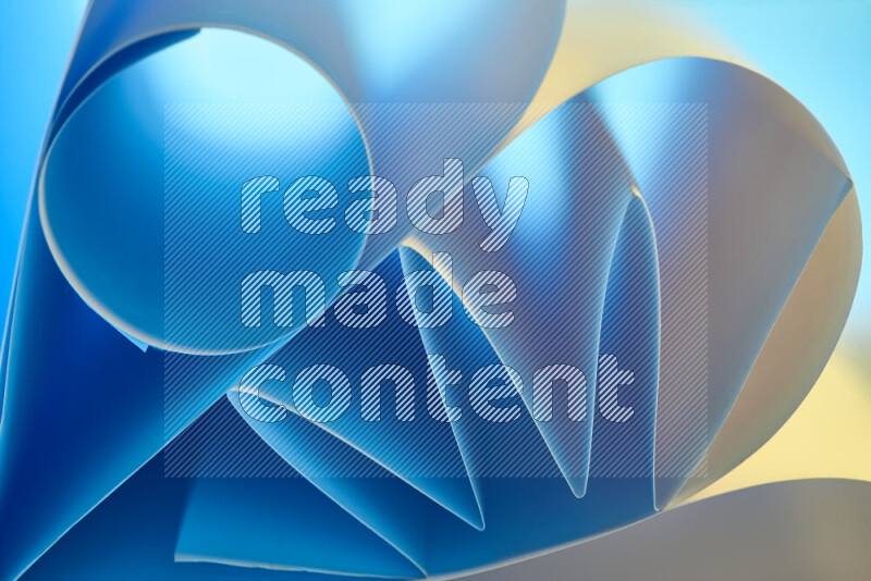 An artistic display of paper folds creating a harmonious blend of geometric shapes, highlighted by soft lighting in blue and warm tones