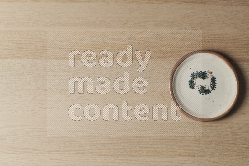 A decorative pottery plate on light wooden background