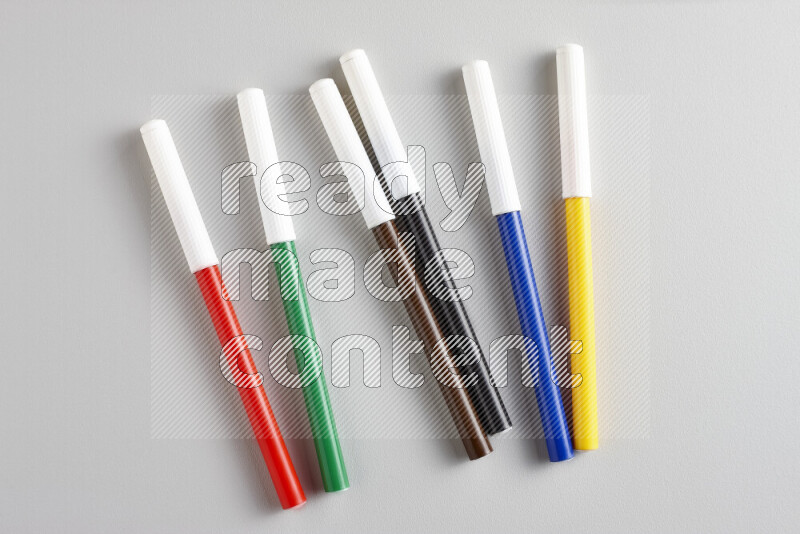 An arrangement of coloring pens in different colors on grey background