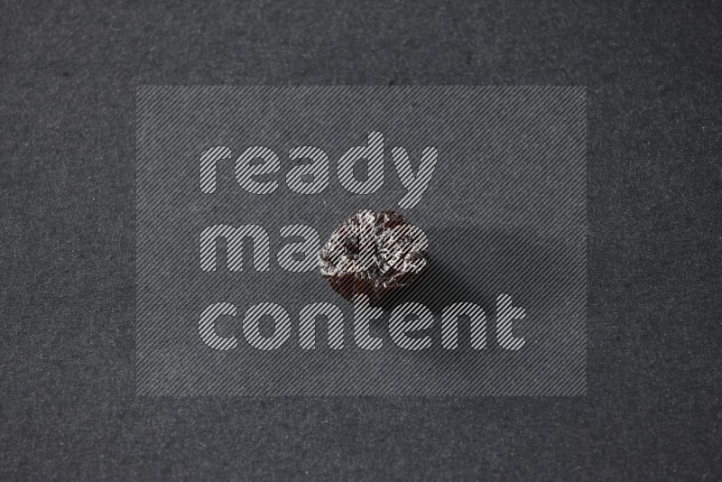 حبة واحدة من البرقوق المجفف على خلفية سوداء