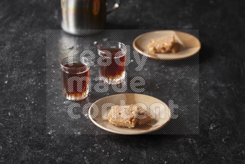 Basbousa with tea in a dark setup