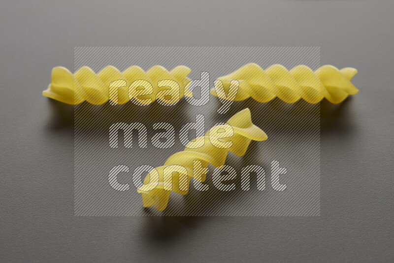 Fusilli pasta on grey background
