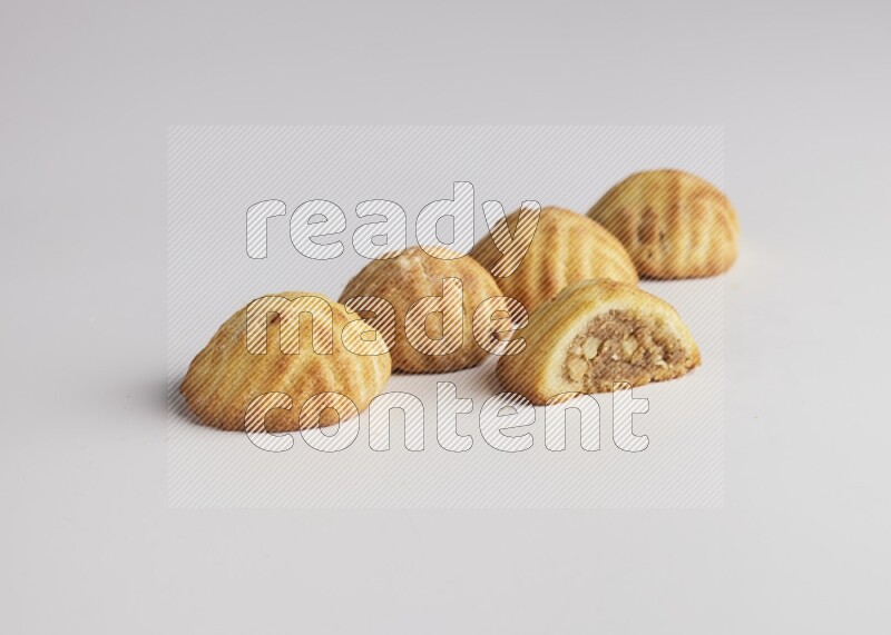 Five Pieces of Maamoul filled with walnut paste  one of them is cut with direct on white background