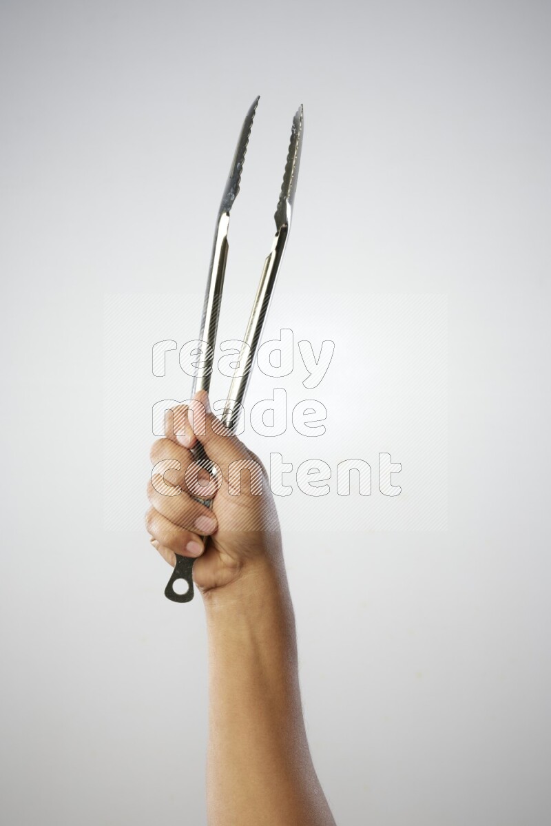 Male Hand Holding Tongs on white background