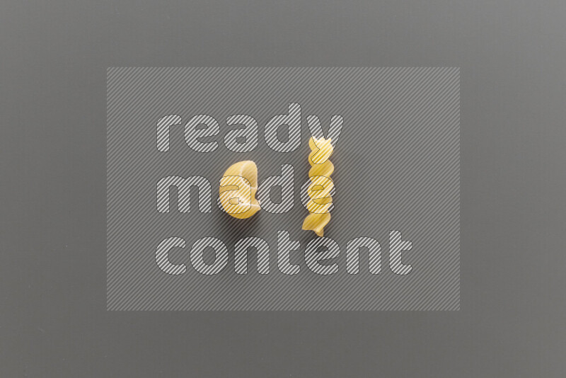 Pipe pasta with other types of pasta on grey background