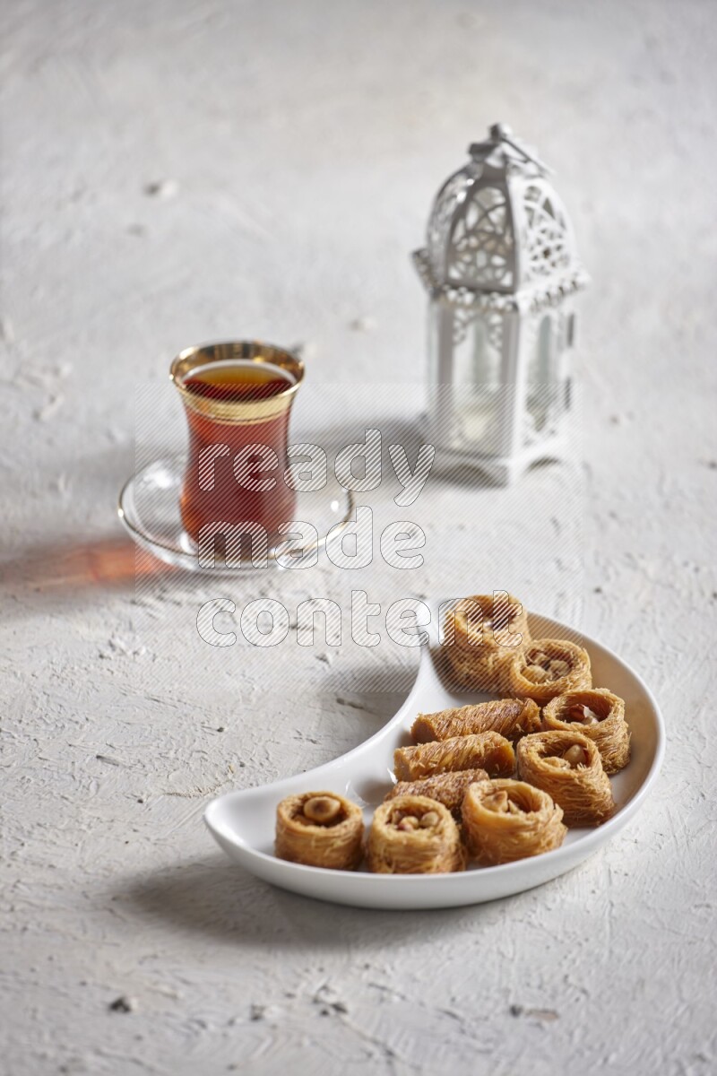 Konafa in a pottery plate with lantern and tea in a light setup