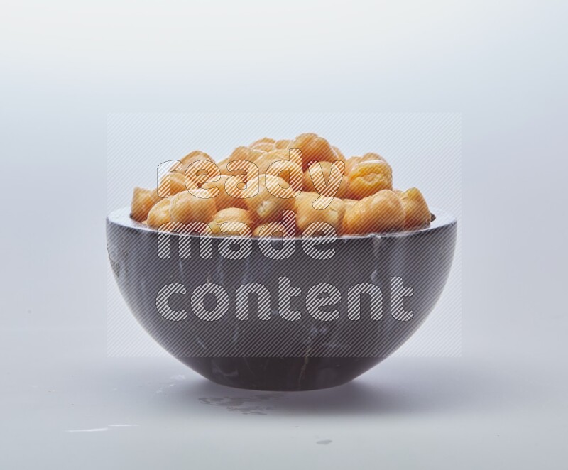 Close up shot of boiled chickpeas in a container on white background