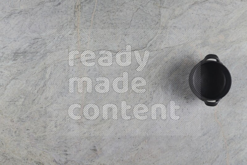 A black pottery bowl on grey marble background