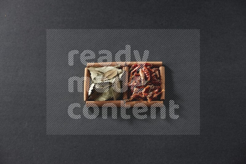 2 squares of cinnamon sticks full of chilis and bay laurel leaves on black flooring